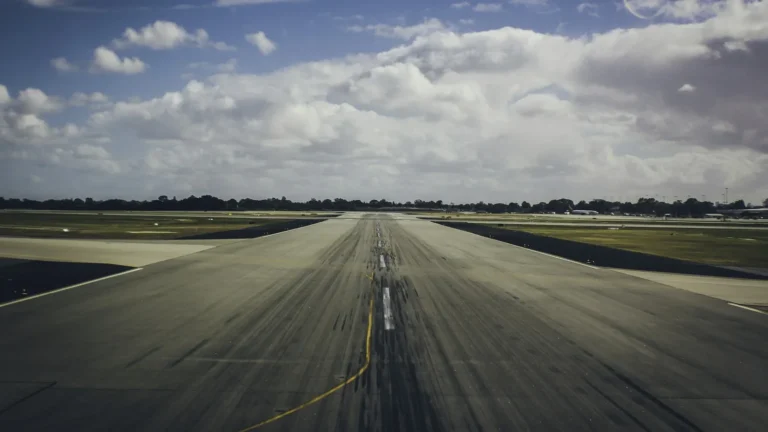 Pista de pouso e decolagem de um aeroporto sob céu com nuvens