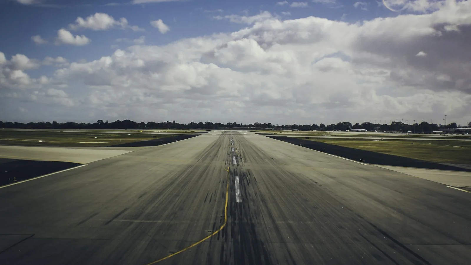 Pista de pouso e decolagem de um aeroporto sob céu com nuvens