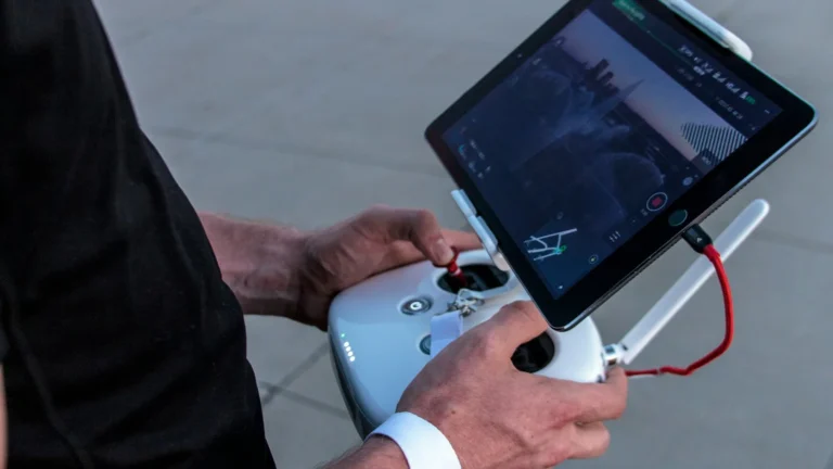 Piloto segurando o controle de drone com tablet mostrando a imagem da câmera