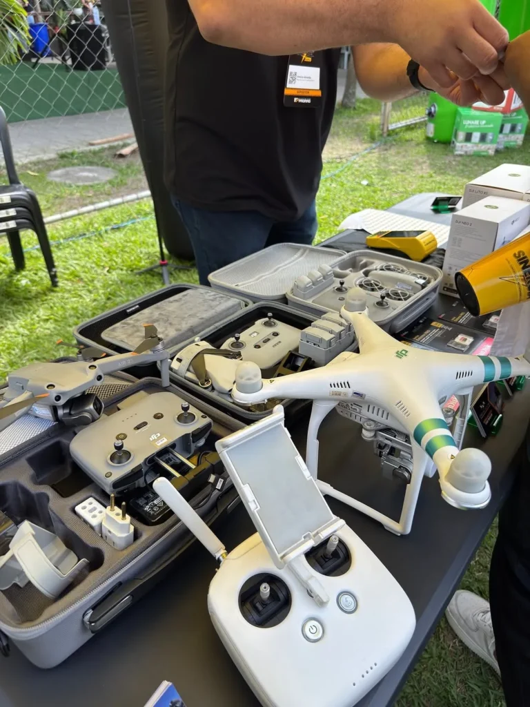 Drones, controles e maletas DJI expostos na mesa da Coelho Eletro durante um evento